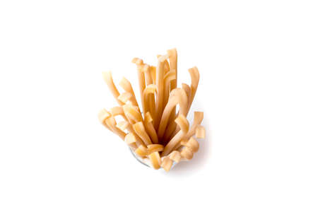 beautiful fresh and raw wholegrain bucatini ,thick, corkscrew shaped pasta on wood board. shallow...
