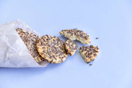 Heap of cookies with flax seeds on blue backgroundの写真素材