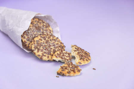 Heap of cookies with flax seeds on purple backgroundの写真素材