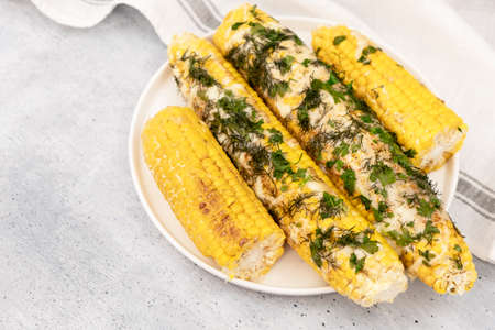 Grilled corn on cob sprinkled with parsley and grated parmesanの写真素材