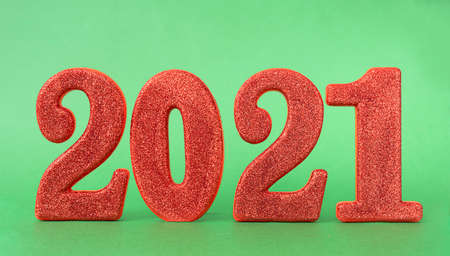New year 2021 celebration. Red digits 2021 with glitter on green background. Xmas. Flat lay.の写真素材