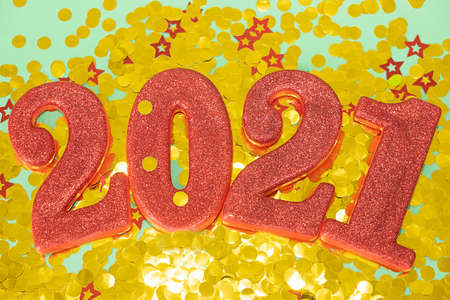 Happy New Year 2021. Red digits 2021 with glitter and xmas decorations nearby. Holiday Party...
