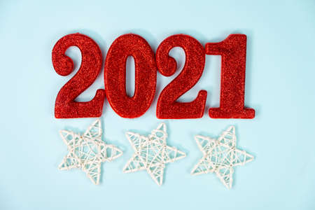 Happy New Year 2021. Red digits 2021 with christmas hat are on Blue background. Holiday Party Decoration or postcard concept with top view and copy space.の写真素材