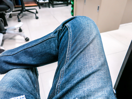 Put on jeans, sit up leg in relaxed position.の写真素材
