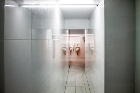 The narrow walkway. There are white walls covered with white tiles.の写真素材