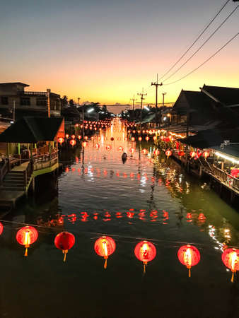 Rivers and canals at dusk are decorated with red circular lights. and old houses on both sides of the riverの写真素材
