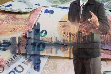 Double exposure of businessman working with new big city and EURO money  background and business strategy as conceptの写真素材