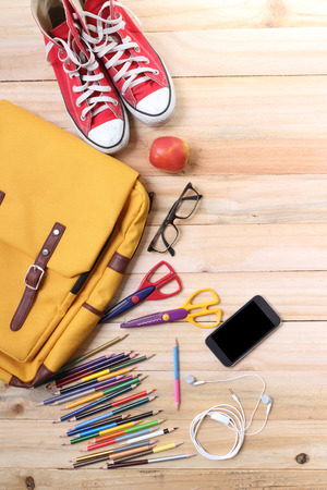 Outfit of traveler, student, teenager, young woman or guy. Overhead of essentials for modern young person. Different objects on wooden background.の写真素材