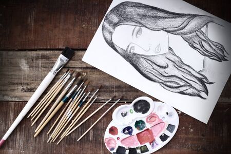 Stylish workspace with  brush and paints on wooden vintage table.の写真素材