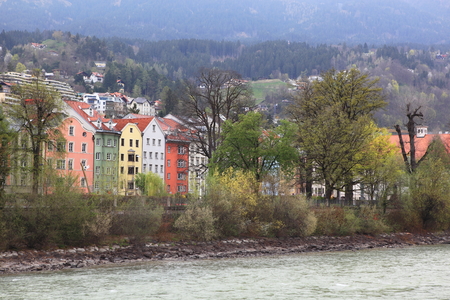 historic architecture, snow capped mountains, and the inn river in the old alpine town of innsbruck, tyrol, austria.の写真素材