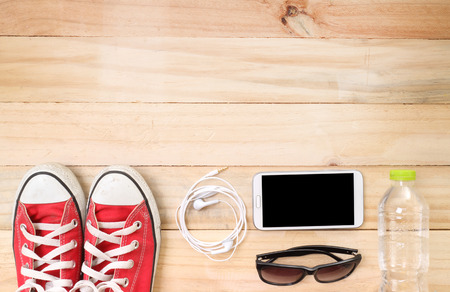 Outfit of traveler, student, teenager, young woman or guy. Overhead of essentials for modern young person. Different objects on wooden background.の写真素材