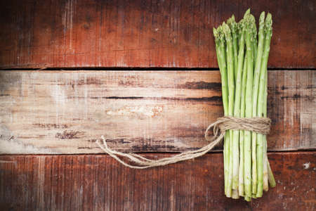 Bunch of fresh asparagus on wooden tableの写真素材