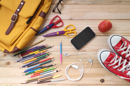 Outfit of traveler, student, teenager, young woman or guy. Overhead of essentials for modern young person. Different objects on wooden background.の写真素材
