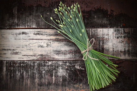 flowering chinese garlic chives on wooden tableの写真素材