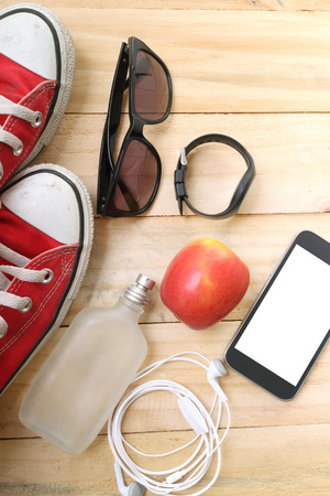 Outfit of traveler, student, teenager, young woman or guy. Overhead of essentials for modern young person. Different objects on wooden background.の写真素材