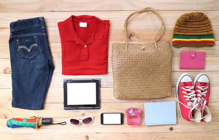 Outfit of traveler, student, teenager, young woman or guy. Overhead of essentials for modern young person. Different objects on wooden background.の写真素材