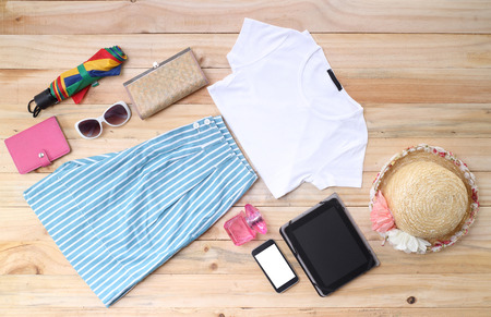 Outfit of traveler, student, teenager, young woman or guy. Overhead of essentials for modern young person. Different objects on wooden background.の写真素材