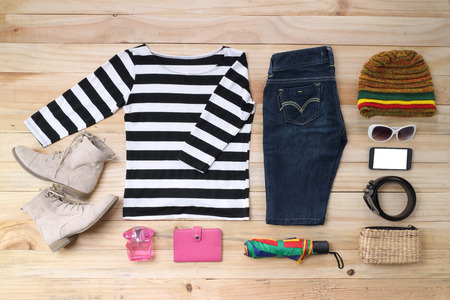 Outfit of traveler, student, teenager, young woman or guy. Overhead of essentials for modern young person. Different objects on wooden background.の写真素材