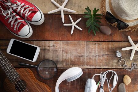 Outfit of traveler, student, teenager, young woman or guy. Overhead of essentials for modern young person. Different objects on wooden background.の写真素材
