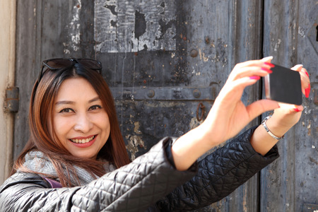 Tourist selfie woman taking self portrait photograph picture with smartphoneの写真素材
