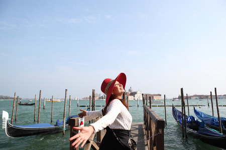Beautiful woman in red  hat against Venice panoramaの写真素材