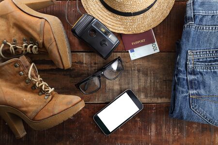 Outfit of traveler, student, teenager, young woman or guy. Overhead of essentials for modern young person. Different objects on wooden background.の写真素材