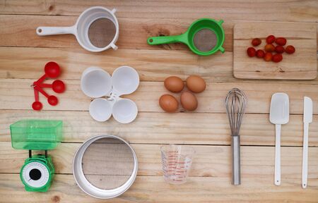 Cooking concept. Basic baking ingredients and kitchen set on wood tableの写真素材
