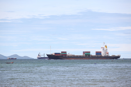 container ship in import,export port against beautiful  blue sky of loading ship yard use for freight and cargo shipping vessel transportの写真素材
