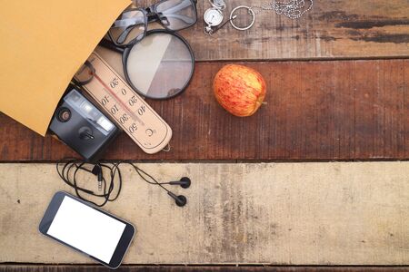 Outfit of traveler, student, teenager, young woman or guy. Overhead of essentials for modern young person. Different objects on wooden background.の写真素材