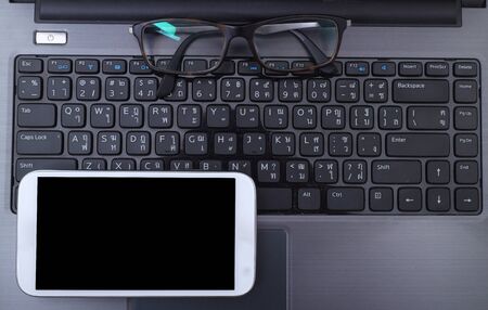 Office workplace with laptop and smart phoneの写真素材