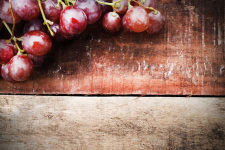 Bunch of red grapes on wooden tableの写真素材