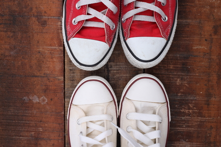 Original Valentine's Day love concept with red and white sneakers. Studio shot on a wooden floor background.の写真素材