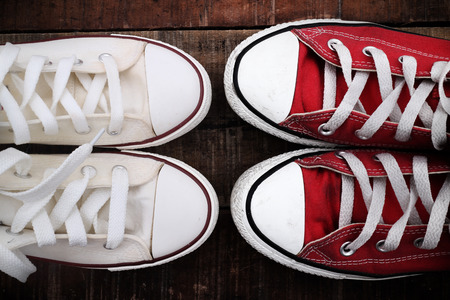 Original Valentine's Day love concept with red and white sneakers. Studio shot on a wooden floor...