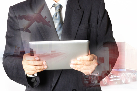 Double exposure of success businessman using digital tablet with container truck ,ship in port and freight cargo plane in transport and import-export commercial logistic ,shipping business industryの写真素材
