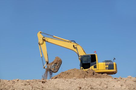 Excavator at a construction site with blue sky