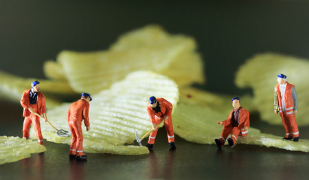 Miniature worker are working with potato chips  Color tone tuned macro photo.の写真素材
