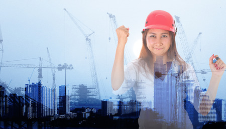 businesswoman with Crane and workers at construction site against blue sky.の写真素材