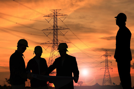 silhouette man of engineers standing at electricity station over Blurred electricity powerの写真素材