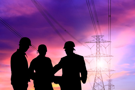silhouette man of engineers standing at electricity station over Blurred electricity powerの写真素材