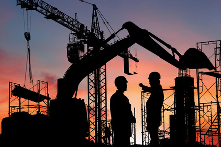 Silhouette engineer standing orders for construction crews to work safely on high ground over blurred natural background sunset pastel. heavy industry and safety at work concept.の写真素材