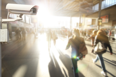 CCTV camera or surveillance operating with crowded people in backgroundの写真素材