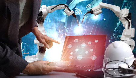 Industry 4.0 concept image. team welding robots represent the movement . In the automotive parts industry.and table of working engineersの写真素材