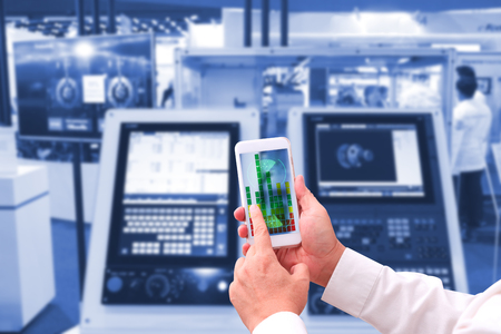 industry 4.0 ,  concept  of Man hand holding tablet with Augmented reality screen software and blue tone of automate wireless Robot arm in smart factory background. mixed media の写真素材