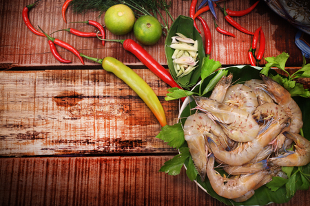Raw Shrimp prepare for cooking,Delicious fresh seafood  on dark vintage background. Fish with aromatic herbs, spices and vegetables - healthy food, diet or cooking conceptの写真素材
