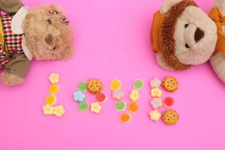 teddy bear with candy on pink backgroundの写真素材