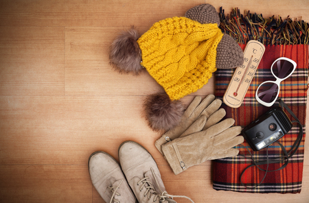flat lay feminine clothes and accessories collage with shirt, jeans shorts, sunglasses, bracelet, sandals, earrings on wood floor background.の写真素材
