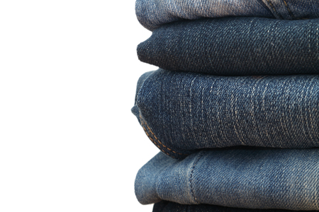 jeans stacked on a wooden table and white background,Pile of jeansの写真素材