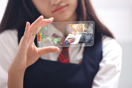 new generation or new business woman use the transparent phone latest technology present the  holography and watch the  technology, future and futuristic technology control global business.の写真素材