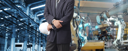 production engineer  with automate wireless Robot arm in smart factory background. Mixed media of welding robot in the automotive parts industryの写真素材