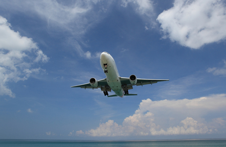 Phuket Thailand âAprilr â15, â2019 Airplane Landing over sea at Phuket Airport, Mai Khao beach phuket thailand, popular landmark tourists people come to take photo of the plane landing over tropicalのeditorial素材